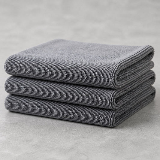 Three folded microfiber truck drying towels on a workbench