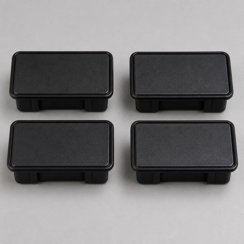 Four black plastic bed stake-pocket covers on a workbench
